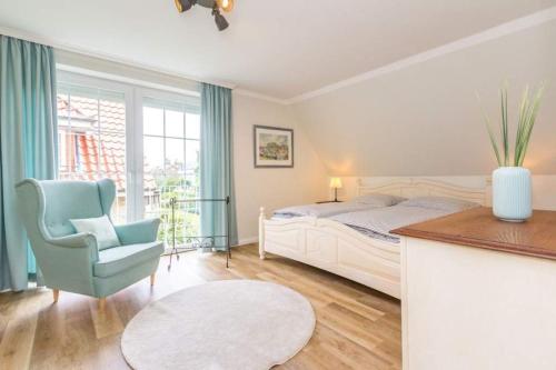 a bedroom with a bed and a chair and a table at Ferienhaus Ankerplatz in Timmendorfer Strand