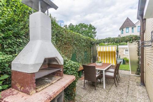 a backyard with an outdoor oven and a table at Ferienhaus Ankerplatz in Timmendorfer Strand