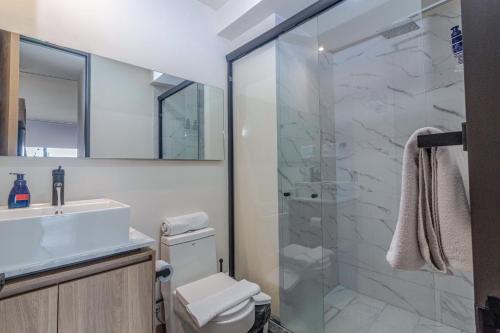 a bathroom with a shower and a toilet and a sink at Loft Urbano con Sala, AC y Vistas, Col Americana 603 in Guadalajara