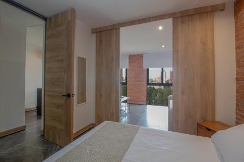 a bedroom with a bed and a sliding door at Loft Urbano con Sala, AC y Vistas, Col Americana 603 in Guadalajara