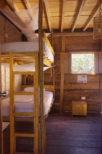 a room with two bunk beds in a cabin at Casa Bambucha Hostel in Las Peñitas
