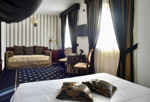 a hotel room with a bed and a couch at Antica Stazione in Chiaramonte Gulfi