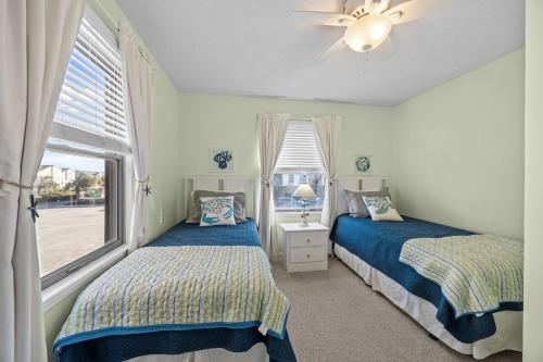 two beds in a room with two windows at OIB90 Endless Summer in Ocean Isle Beach