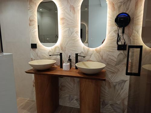 a bathroom with two sinks and a mirror at Ursino inn camere e suite in Catania