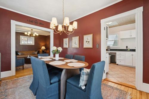 a dining room with a table and blue chairs at State St Parlor Walk Downtown Newly Designed in Portsmouth