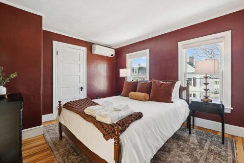 a bedroom with a large bed with red walls at State St Parlor Walk Downtown Newly Designed in Portsmouth