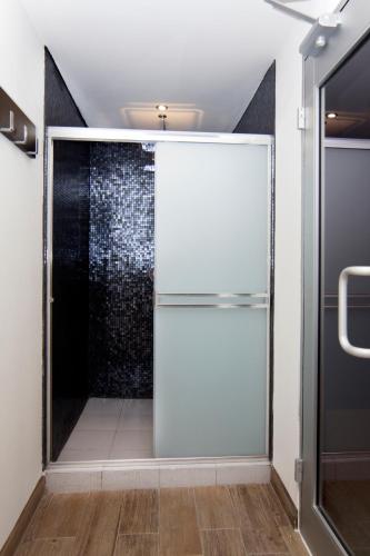 a white refrigerator in a bathroom with a shower at Hotel Ticuán in Tijuana