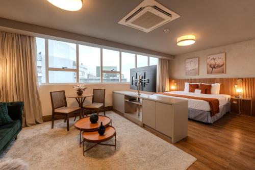 a bedroom with a bed and a living room at Hotel Heritage in São Paulo