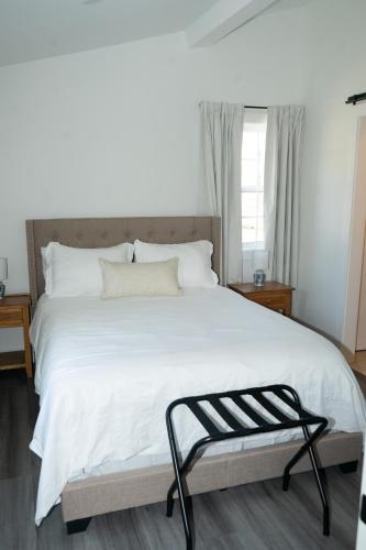 a bedroom with a large white bed with a bench at Peace Barn Getaway in Carrollton
