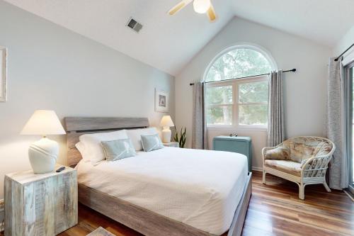 a bedroom with a large bed and a chair at SB25 Clubhouse Villa 3BR in Sunset Beach
