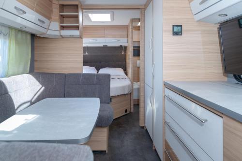 a small caravan with a couch and a bed at Wohnwagenvermietung Sylt in Rantum