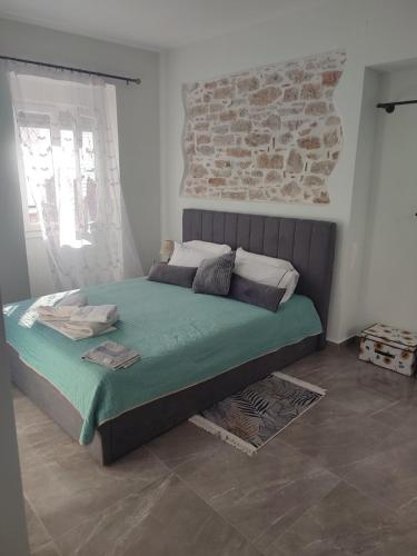 a bed in a bedroom with a brick wall at Το σπιτι στη Ρουγα in Glossa