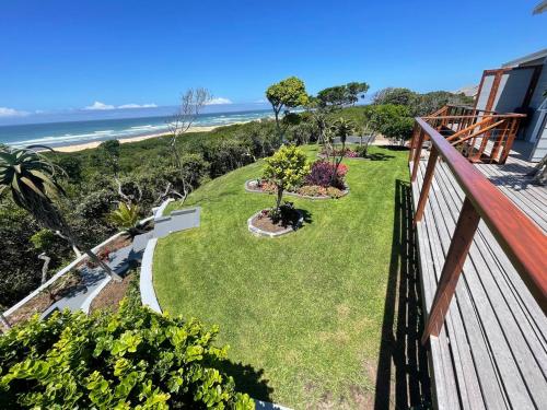 a view from a balcony of a yard with the beach at Huis Seenekal in Cannon Rocks