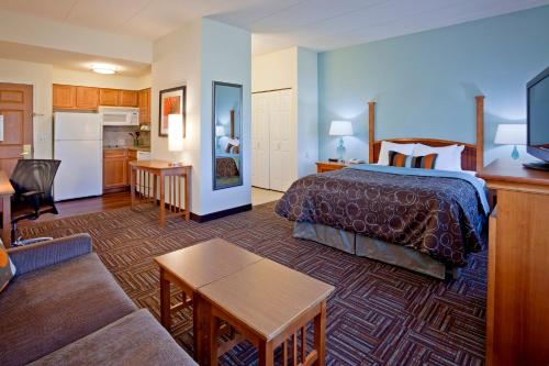a hotel room with a bed and a living room at Candlewood Suites Eagan - Mall of America Area by IHG in Eagan