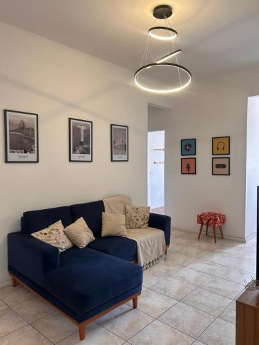 a living room with a blue couch and a table at Apê 5 min da praia de Copacabana, Pet Friendly in Rio de Janeiro