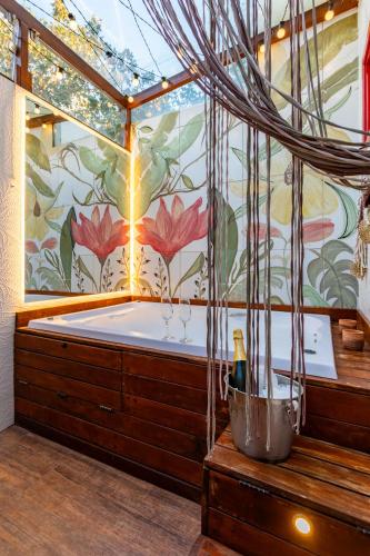 a jacuzzi tub in a room with a flower mural at CasinhaPiri in Pirenópolis