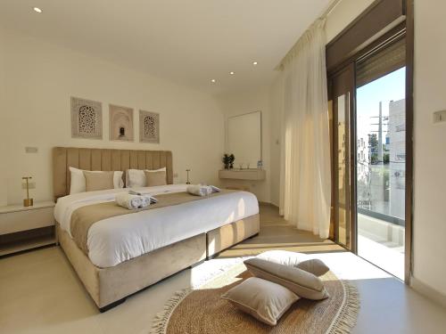 una camera da letto con un grande letto e una grande finestra di ذا سهل ستيز ad Amman