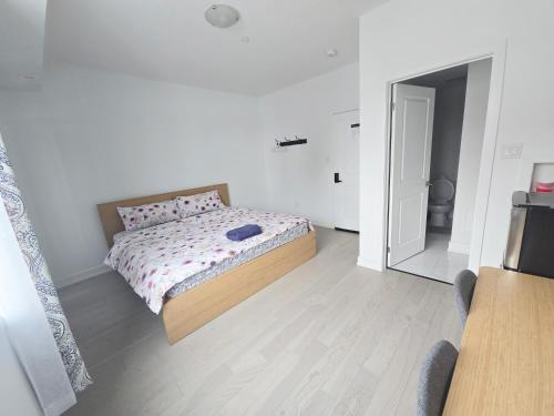 a white bedroom with a bed and a mirror at Modern Private Room Private Bathroom with King Bed with TV and Optional Balcony 10 minutes to Rogers Stadium Midtown Downtown Toronto in Toronto