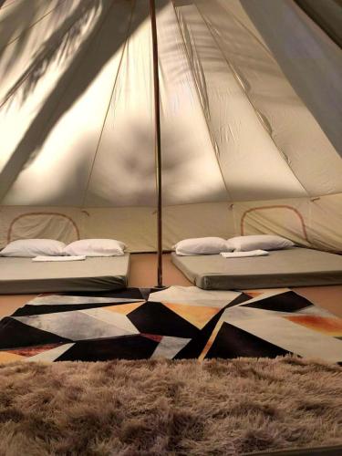 two beds in a tent with a rug at Campo De Laiya in San Juan