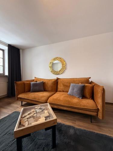 a living room with a brown couch and a table at Ferienwohnungen am Luitpold in Berchtesgaden