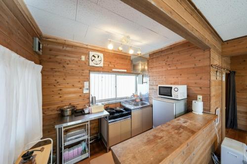 a kitchen with wooden walls and a counter top at ガチンコBBQロッジ北軽井沢 in Tsumagoi