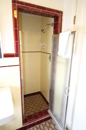 
a bathroom with a shower, sink, and mirror at Wigwam Motel in San Bernardino
