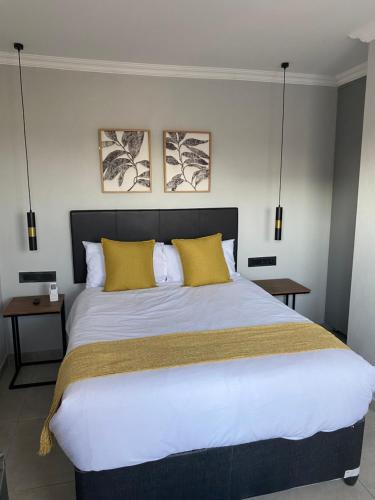 a bedroom with a large bed with yellow pillows at Black Rose Guesthouse Northam in Northam