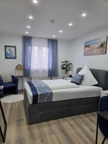 a bedroom with a large bed and a blue chair at Kings Apartments in Ingolstadt