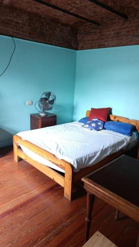 a bed in a room with a blue wall at hotel tango club in Buenos Aires