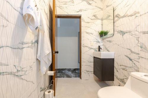 a bathroom with a toilet and a sink at Oz Residence Beach Two-Bedroom Apartment & Free Parking in Los Botados