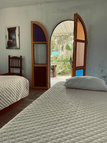 a bedroom with two beds and an open door at ECOHostal las Hamacas in Villamaría