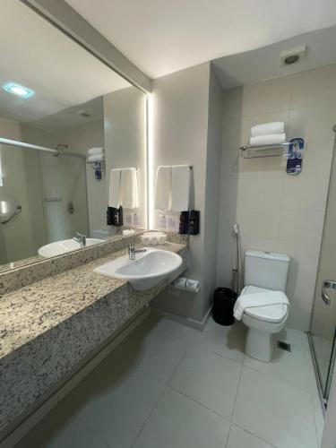 a bathroom with a sink and a toilet and a mirror at Holiday Inn Express Belem Ananindeua by IHG in Belém