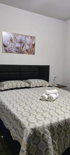a bed with two towels on it in a bedroom at Habitaflex Casa No Centro de Urupês in Urupês