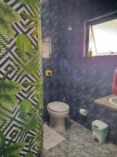 a bathroom with a toilet and a plant at Lar da Lilika Temporada in Cabo Frio