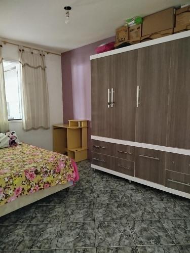 a bedroom with a bed and a large cabinet at Lar da Lilika Temporada in Cabo Frio