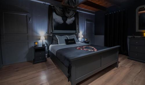 a bedroom with a large bed with blue walls at L' Antre de L' Ange in Trédarzec