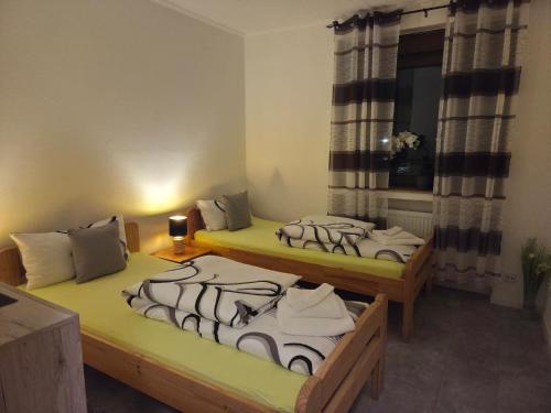 two twin beds in a room with a window at AS Apartment Neukirchen-Vluyn in Neukirchen-Vluyn