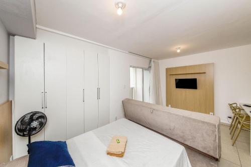 a small bedroom with a bed and a table at Studio Vibe 2206 com Piscina/academia/varanda in Juiz de Fora