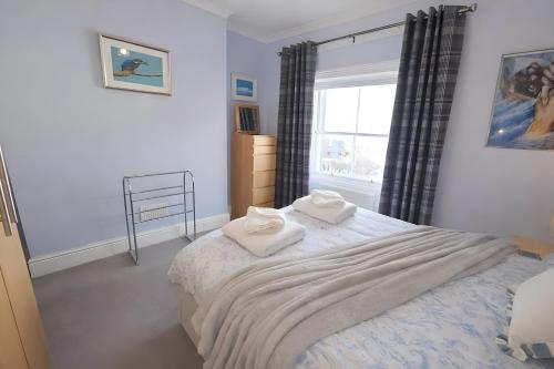 a bedroom with a bed with two towels on it at Dog Friendly Lakeland Apartment - Private Parking - Central Location in Cockermouth