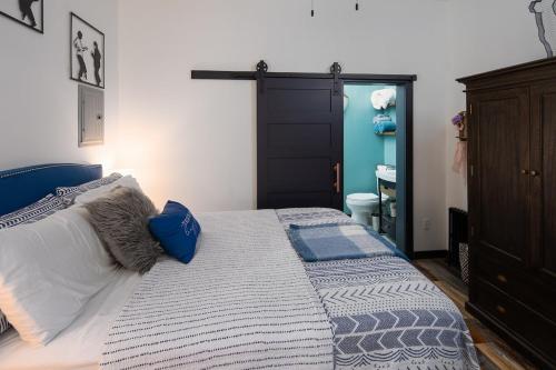 a bedroom with a bed and a blue door at The Alibi- We will cover for you in Port Clinton