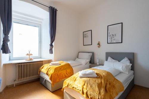 two beds in a room with a window at COY Apartments Leoben - Central near Uni & Station with 24 7 Check-in in Leoben