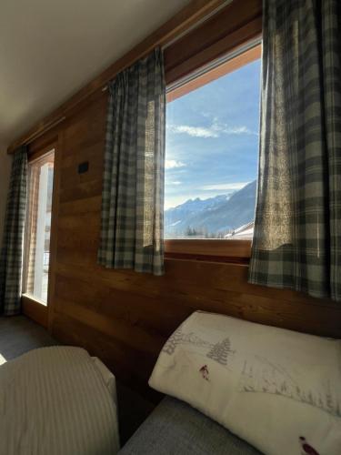 a bedroom with a bed and a large window at Baita Piazza in Valdisotto