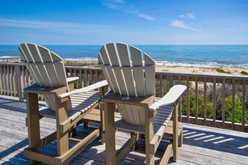 two chairs sitting on a deck overlooking the beach at Breakaway - Duck, Sanderling, Oceanfront, Ocean View, Pets OK, Community Pool in Duck