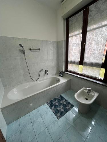 a bathroom with a bath tub and a toilet at AlbaChiara Apartment in Gallarate
