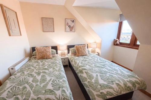 two beds in a small room with two lamps at Inverness Holiday House - 2 Bedroom in Inverness
