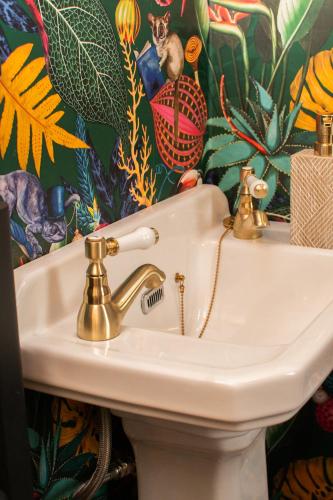 a white sink in a bathroom with a colorful wallpaper at Inverness Holiday House - 2 Bedroom in Inverness