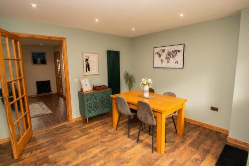 a dining room with a wooden table and chairs at Inverness Holiday House - 2 Bedroom in Inverness