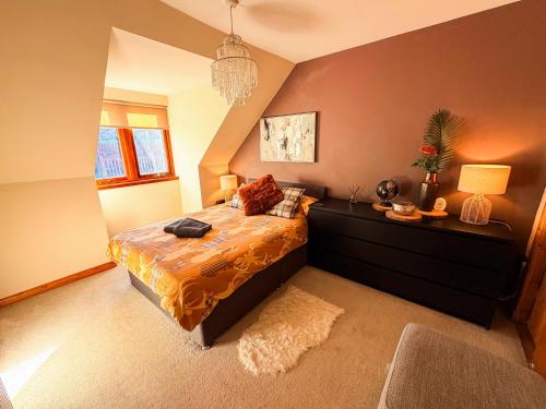 a bedroom with a king sized bed and a dresser at Inverness Holiday House - 2 Bedroom in Inverness