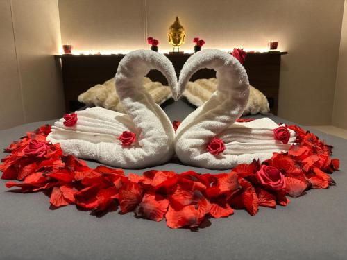 two towelsrendered to look like swans on a bed at Tiny house climatisé et jacuzzi privatif in Saint-Loup-Nantouard