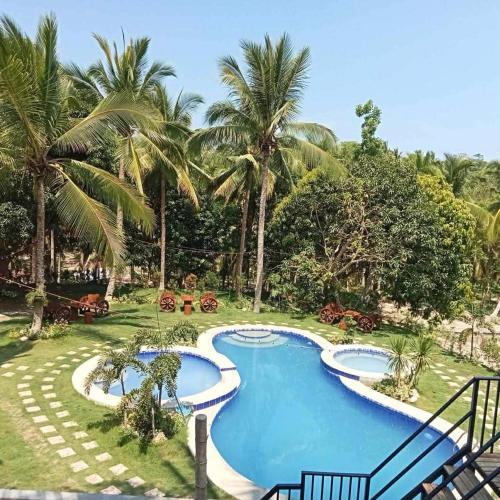 a swimming pool in a resort with palm trees at Campo De Laiya in San Juan